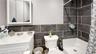 Bathroom with tile walls, vanity, curtained shower, and toilet
