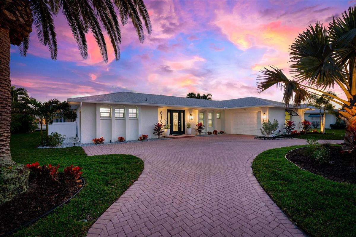 Front elevation at twilight with large circular driveway