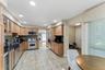 Kitchen featuring wood cabinetry, dark countertops, tiled backsplash, and stainless steel appliances