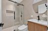 Frameless glass shower enclosure with matte black hardware