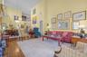 Living room featuring a high ceiling, hardwood / wood-style flooring, stairway, and crown molding