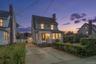 Two-story residence featuring light-toned siding and multiple windows