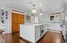 Kitchen featuring white cabinets, light countertops, ornamental molding, and stainless steel oven