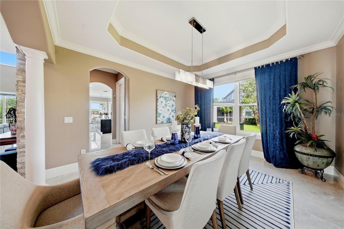 Formal dining room with architectural columns and tray ceiling