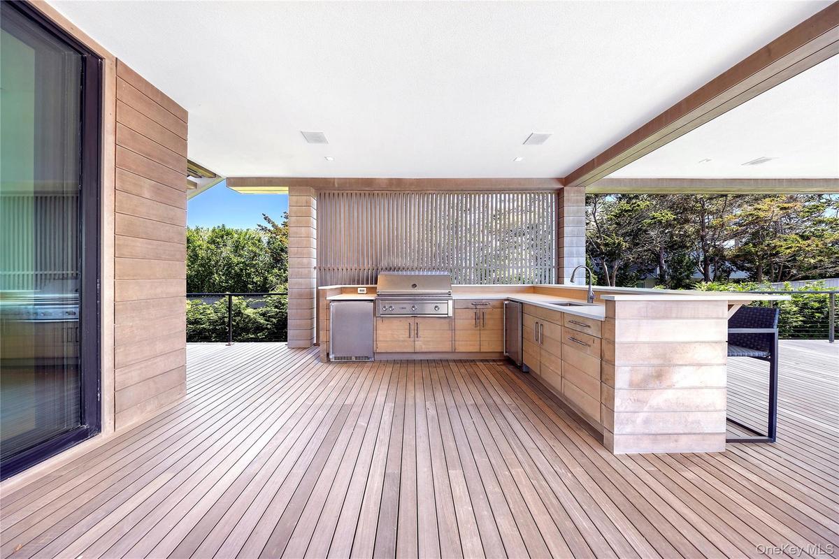Deck with an outdoor kitchen and a sink