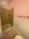 Full bathroom with a wainscoted wall, a stall shower, and ornamental molding