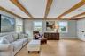 Living area with light wood finished floors and beam ceiling
