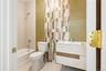 Bathroom featuring bathtub / shower combination, vanity, and tile walls