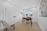 Recessed lighting, wood-finish flooring, and white walls with thick baseboards