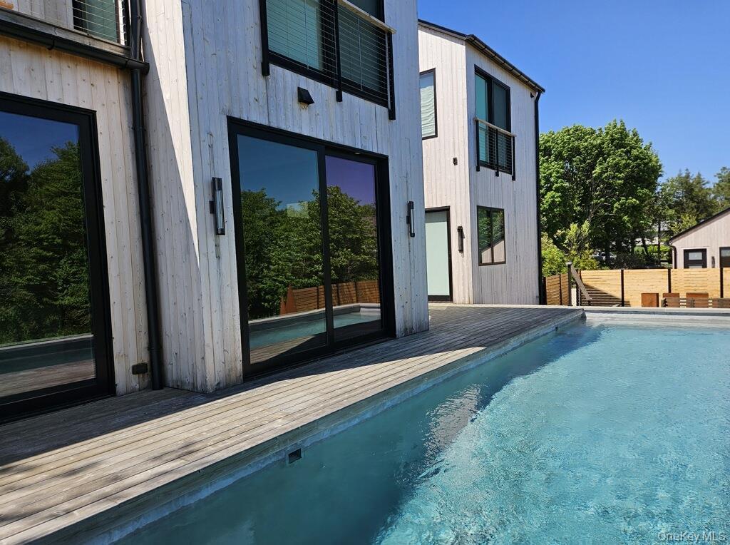 View of swimming pool with a deck and a fenced in pool
