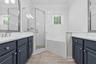 En-suite Primary bath has upgraded quartz counters glass enclosed shower and large soaking tub.