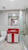 Full bathroom featuring shower / tub combination, vanity, tile walls, and light tile patterned flooring