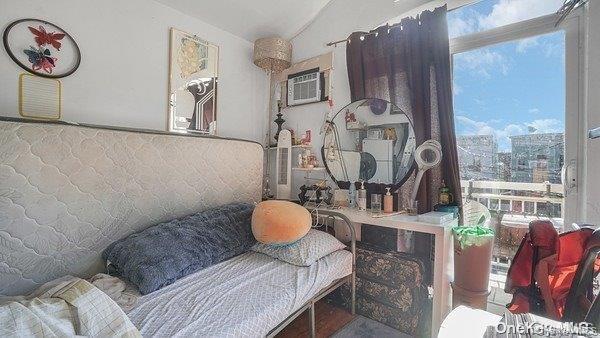 Living area featuring healthy amount of natural light, a wall mounted air conditioner, and vaulted ceiling