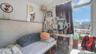 Living area featuring healthy amount of natural light, a wall mounted air conditioner, and vaulted ceiling