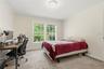 Light-toned carpeted room featuring two large windows, white trim, and neutral wall paint