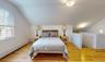 Bedroom featuring a baseboard heating unit, vaulted ceiling, and light wood-type flooring