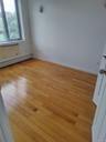 Unfurnished room featuring baseboard heating and light wood-style floors