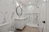 Bathroom with a marble finish shower and vanity