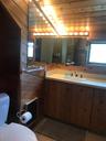 Bathroom featuring wooden walls, toilet, and a healthy amount of sunlight