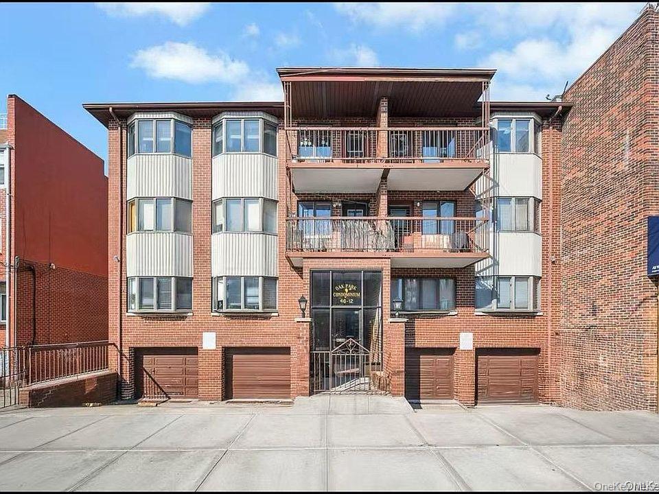 View of apartment building / complex with driveway and a garage
