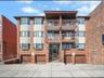 View of apartment building / complex with driveway and a garage
