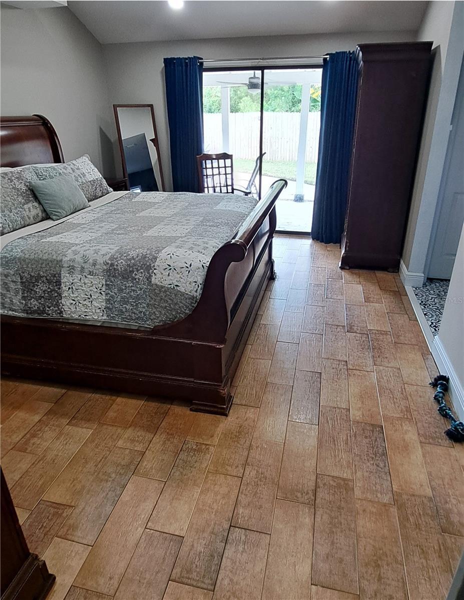 Primary bedroom with access to pool and backyard