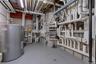 Utility room showcasing extensive plumbing and mechanical systems