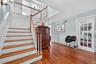 Staircase with a decorative wall, wainscoting, wood finished floors, and a baseboard radiator