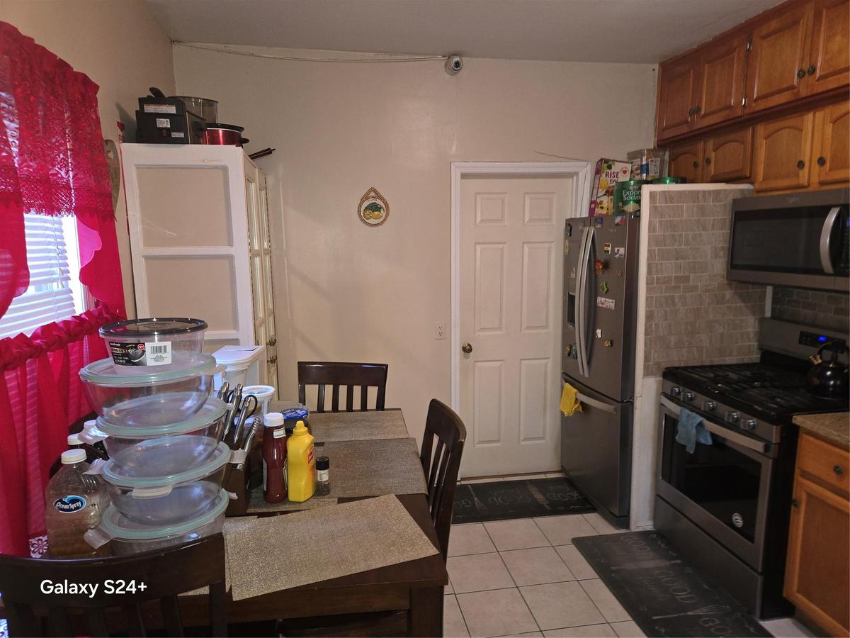 Kitchen featuring fridge, backsplash, range, and light tile patterned floors