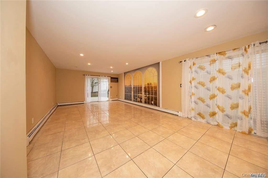 Den with tile floors. Sliders leading to patio area outside.