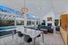 Ideal entertaining Space: Living room and dining area flanked by wall to wall glass sliders to patio, pool, tennis with a wood burning fireplace, dren