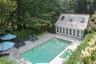 View of swimming pool with a patio area, a pool with connected hot tub, an exterior structure, and an outbuilding