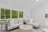 Living room featuring baseboards, light colored carpet, and high vaulted ceiling