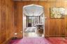 Carpeted entrance foyer with baseboards, wooden walls, and a paneled ceiling