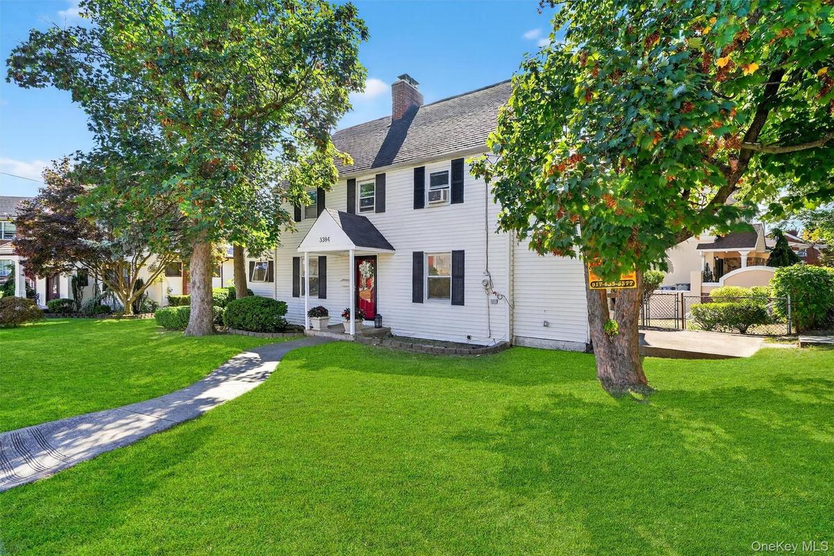 Colonial-style house with a chimney and roof with shingles