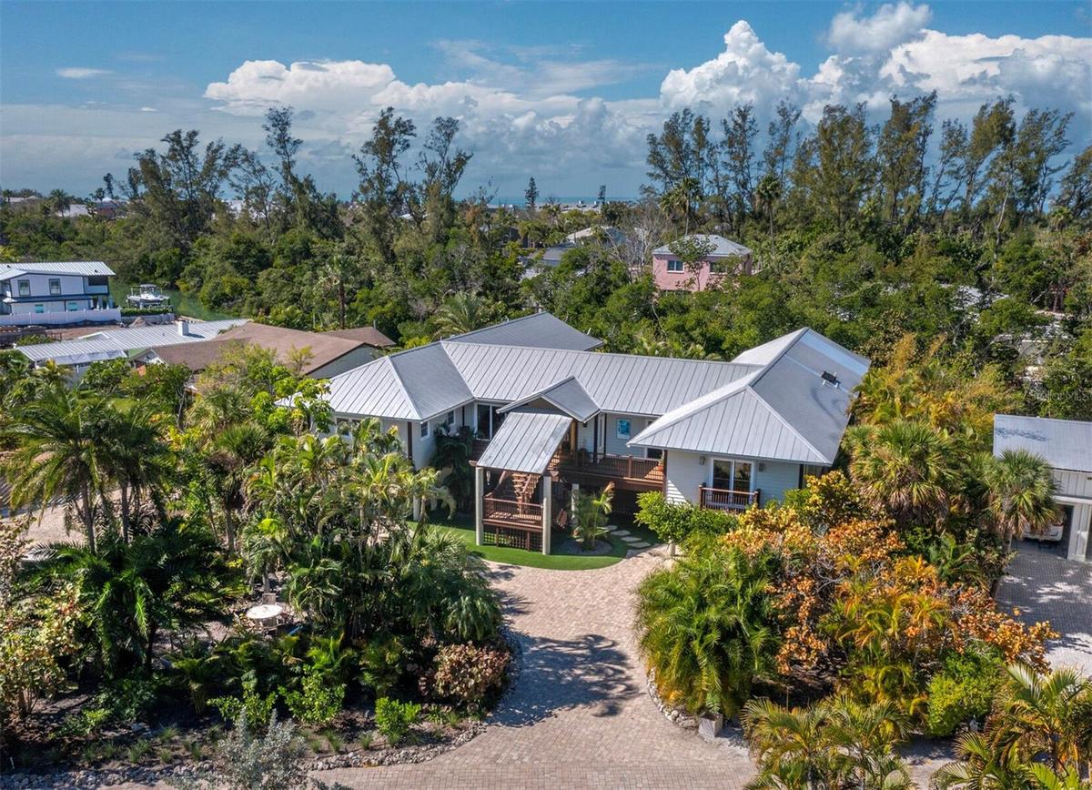 This zen-like beautiful home boasts 4,000 sf of tranquil elevated living, soaring ceilings, and walls of glass overlooking the tropical natural bayou,