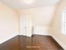3rd fl Sloped ceiling room featuring wood-finish flooring, a white paneled door, and a single window