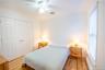 Bedroom with multiple windows, a closet, wood finished floors, and crown molding