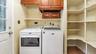 Washroom with washing machine and clothes dryer, cabinet space, and baseboards