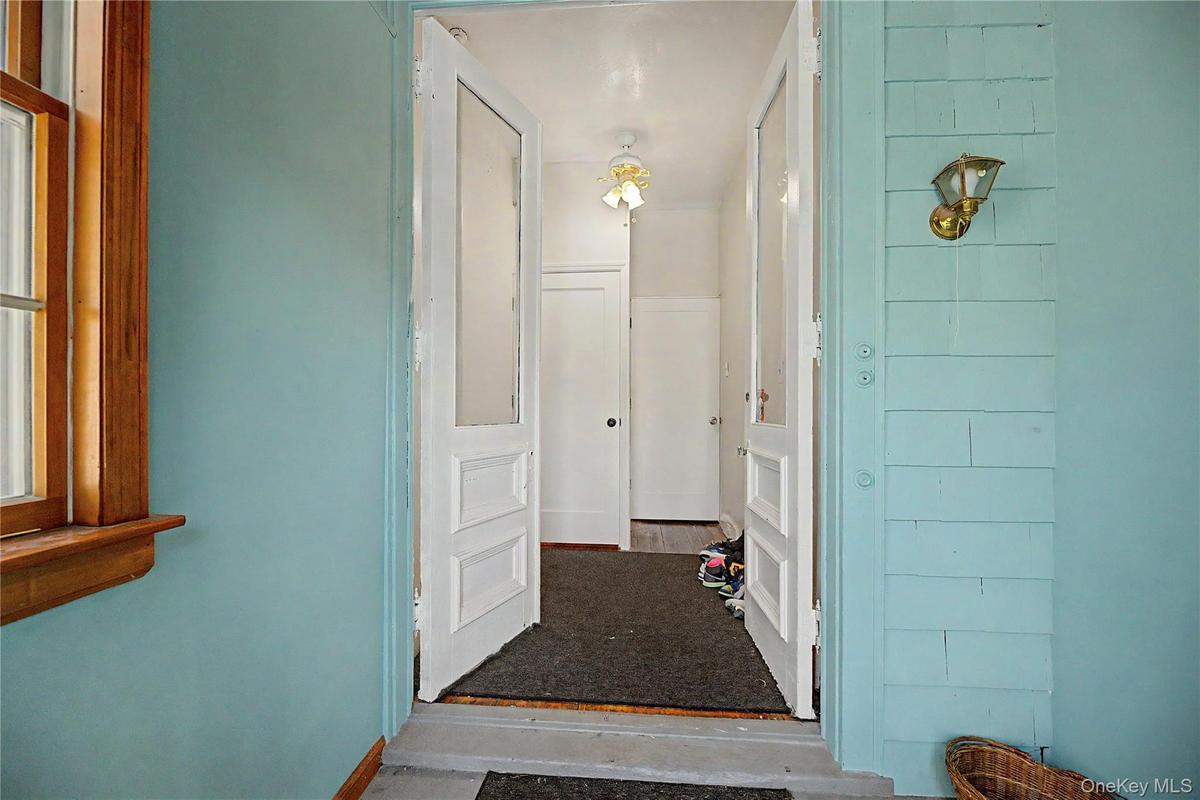 Entryway featuring a wood-framed window, a decorative exterior light fixture, and a glass-paneled entry door