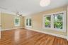Multiple windows frame leafy neighborhood views, giving the primary bedroom a bright and peaceful feel.