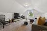 Living area featuring lofted ceiling, carpet flooring, and a wall mounted air conditioner