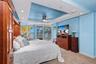 Primary Suite captures sweeping Gulf views and features direct balcony access, an adjustable split-top king bed, tray ceiling with ceiling fan, and TV