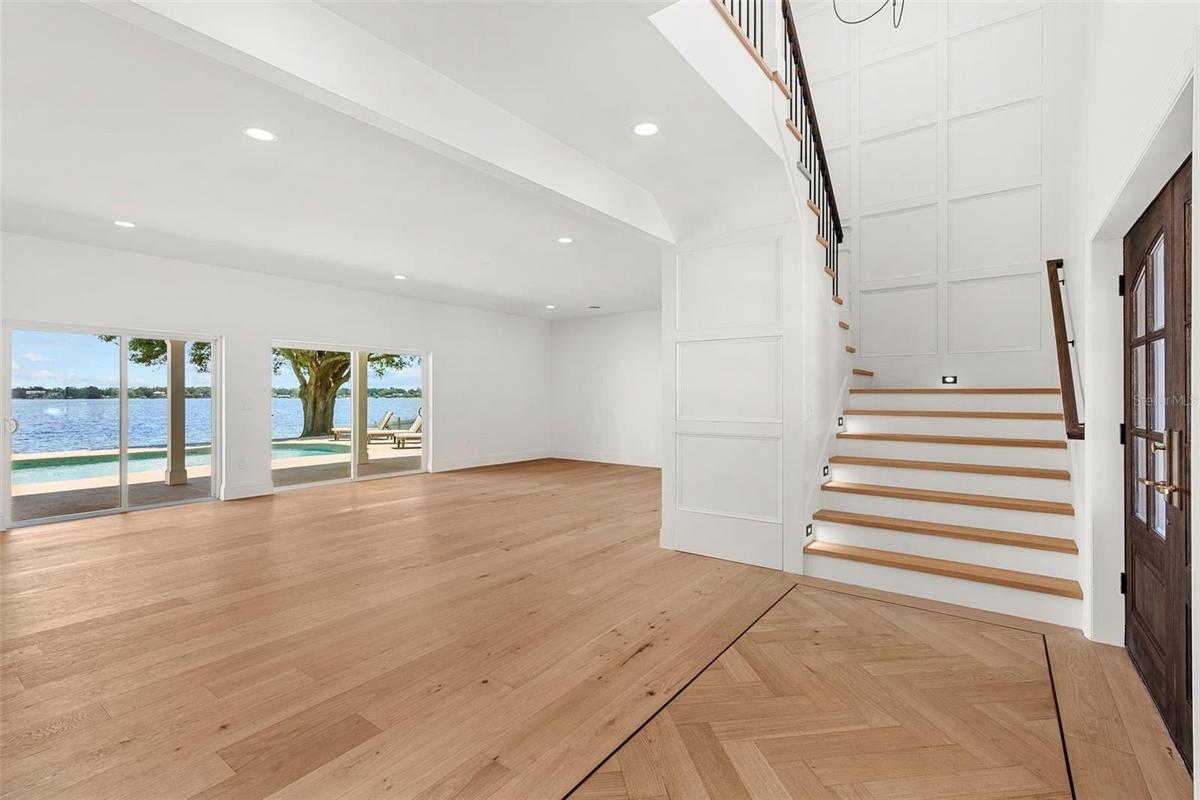 ELEGANT STAIRCASE ASCENDING TO A LOFT SANCTUARY WITH BREATHTAKING BALCONY VIEWS OF LAKE CONWAY