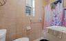 Bathroom featuring floor-to-ceiling square wall tiles, a white toilet, and a vanity with an integrated sink