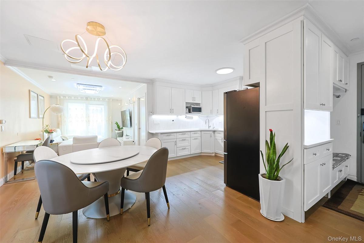 Dining area with light wood-type flooring, crown molding, and a chandelier