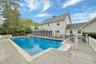 View of pool with a sunroom and a wooden deck