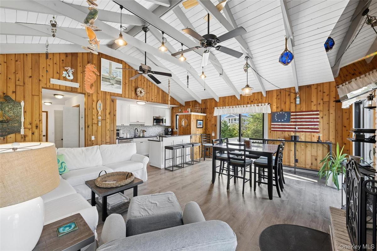 Vaulted white wood beam ceiling throughout an open concept living area featuring wood-finish flooring