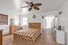 Bedroom featuring a baseboard radiator, ceiling fan, and light tile patterned flooring