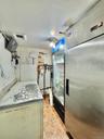 Kitchen featuring light tile patterned flooring, heating unit, and freestanding refrigerator